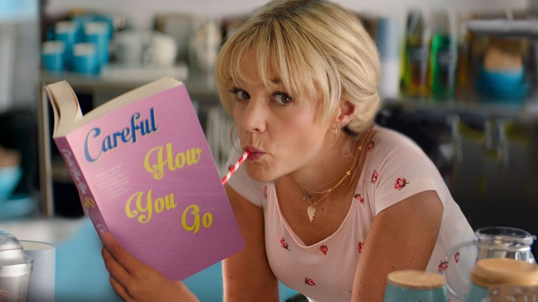 Cassie drinking from straw pink book