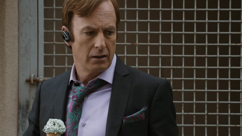 Saul Goodman holds an ice cream cone in front of a wall