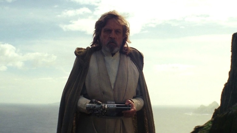 Luke Skywalker holds lightsaber