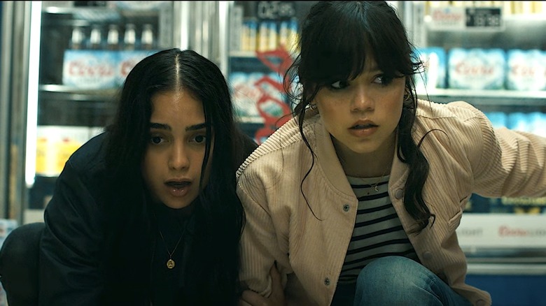 Sam and Tara crouching in grocery aisle