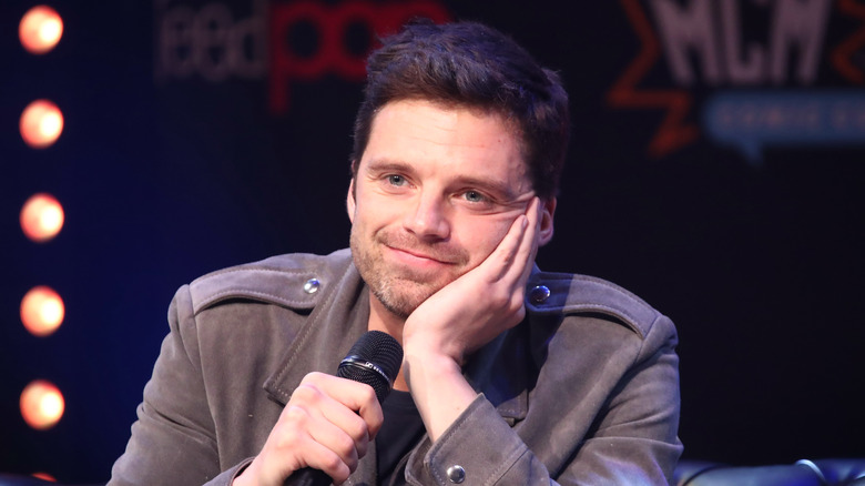 Sebastian Stan resting face on hand wistfully 