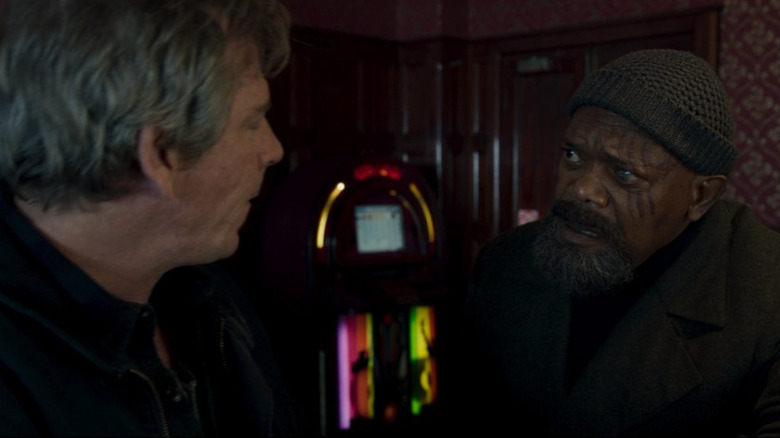 Talos and Nick Fury speaking at a bar