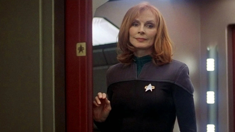 Dr. Crusher stands in a doorway