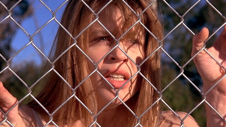 Sarah stands at a fence