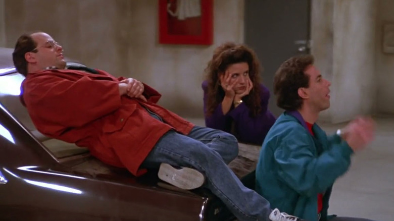 George, Elaine, and Jerry leaning on a car