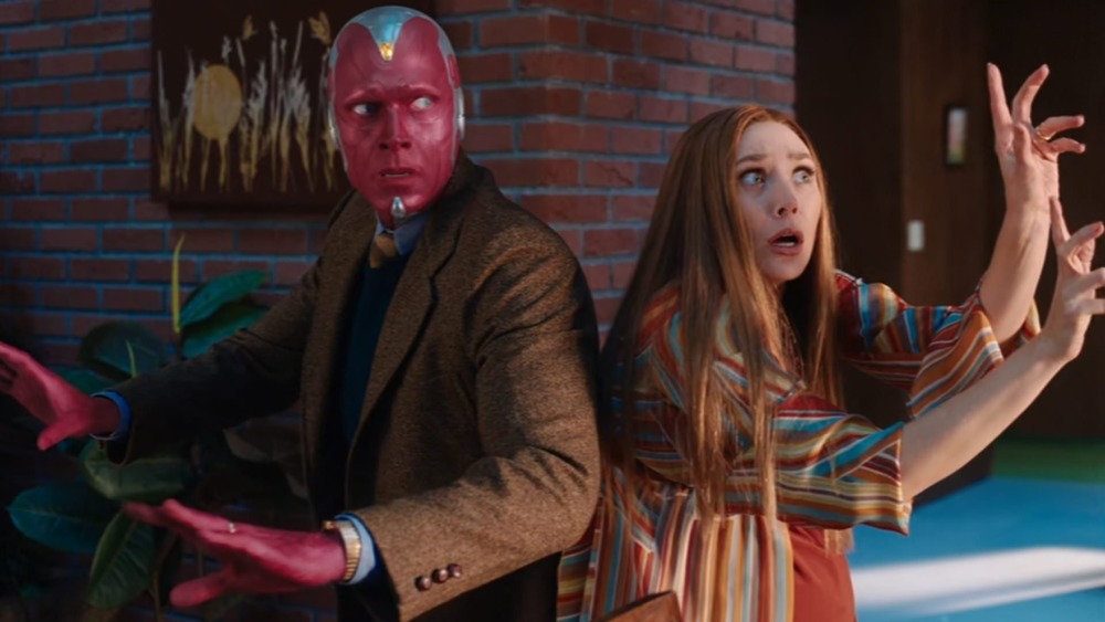 Wanda and Vision back to back with their hands up