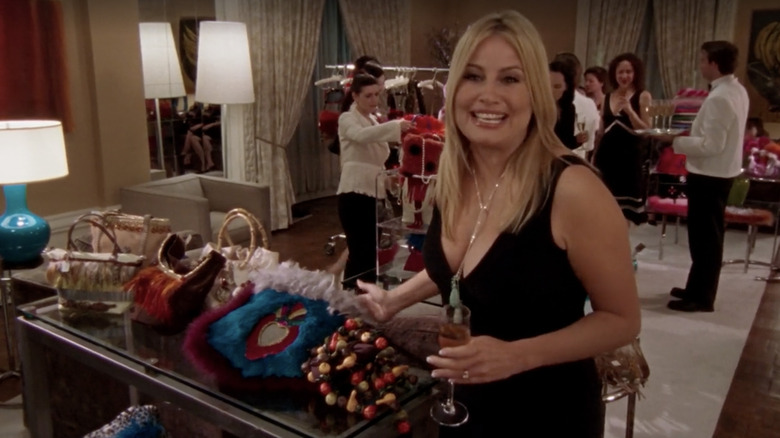 Jennifer Coolidge smiling next to purses