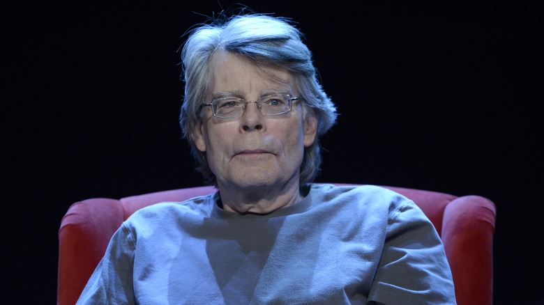 Stephen King scowls red chair