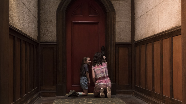 Two of the young Crain children at a locked door in The Haunting of Hill House