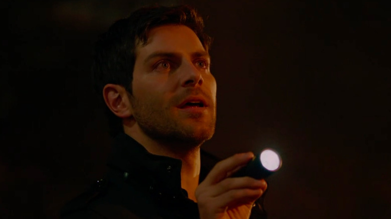 David Giuntoli as Nick examining a supernatural crime scene on Grimm