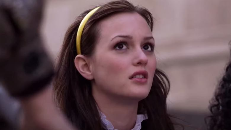 Blair in yellow headband looks up skeptically