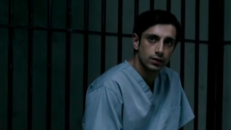 Riz Ahmed sitting alone in a jail cell in The Night Of