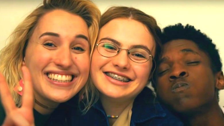 Mallory, Jeanette, and Vince in a photo booth in Cruel Summer