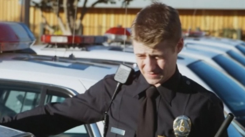 Ben Sherman leans on squad car