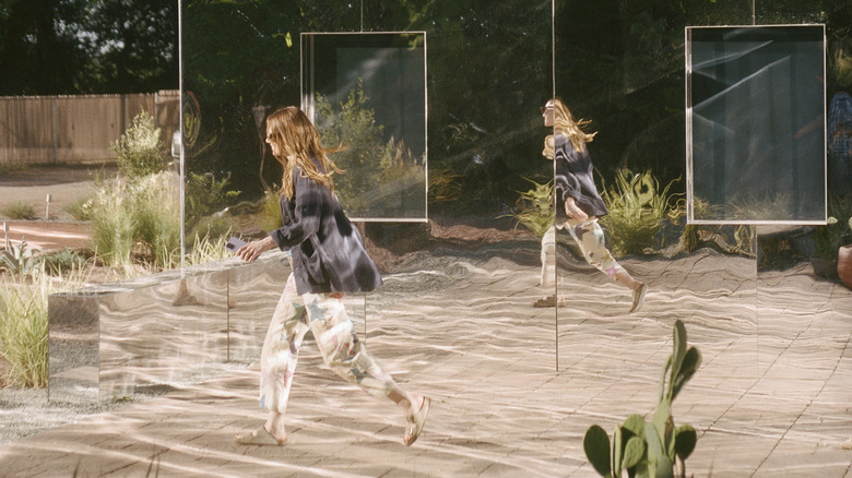 Whitney walks past mirrored house