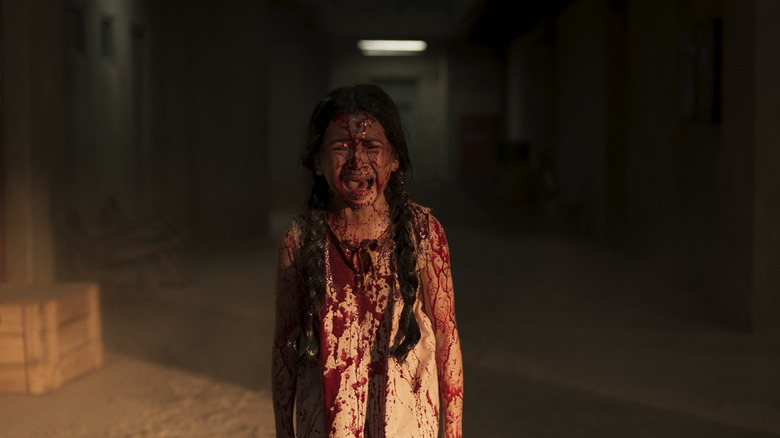 A young girl drenched in blood