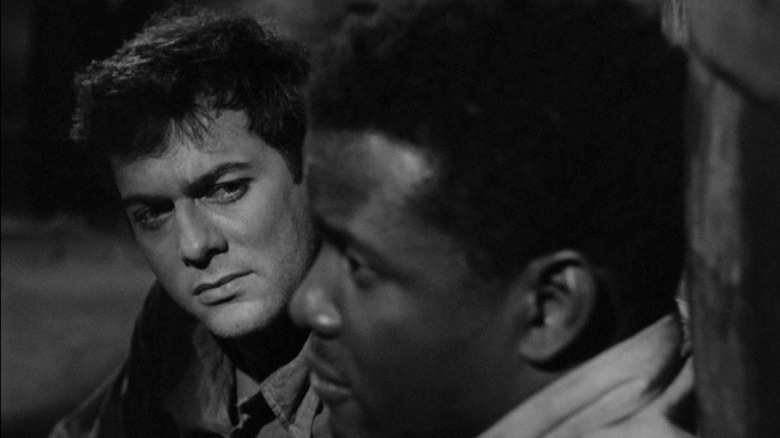 Tony Curtis sits next to Sidney Poitier in The Defiant Ones