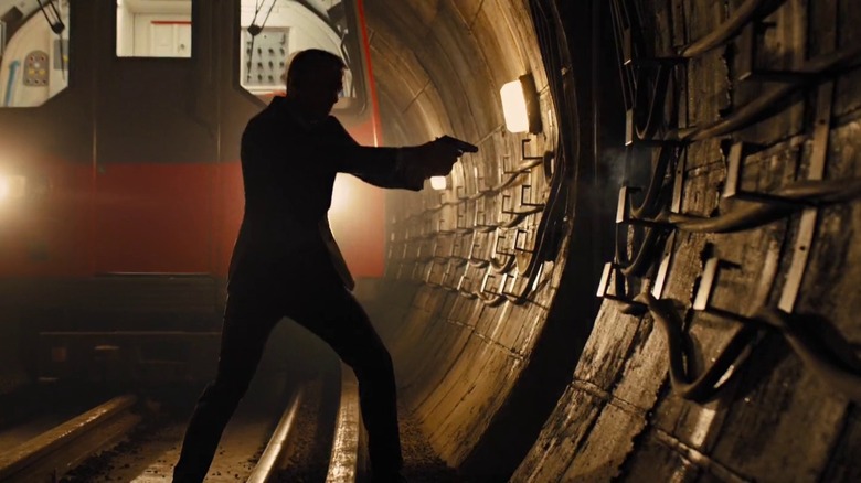 The silhouette of James Bond aims a gun in front of a train