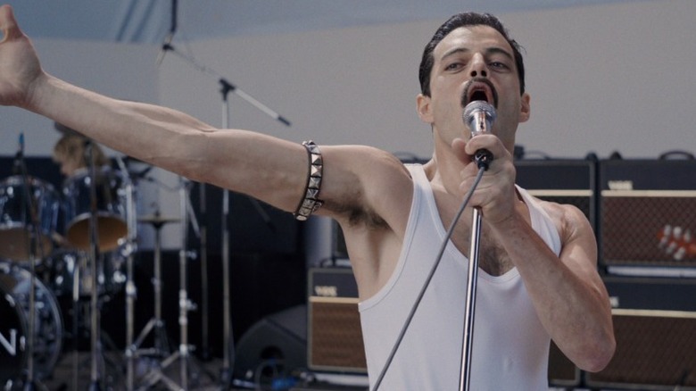 Freddie sings with his arm outstretched