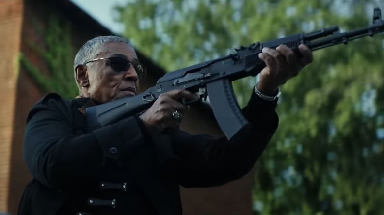 Man in sunglasses aiming rifle