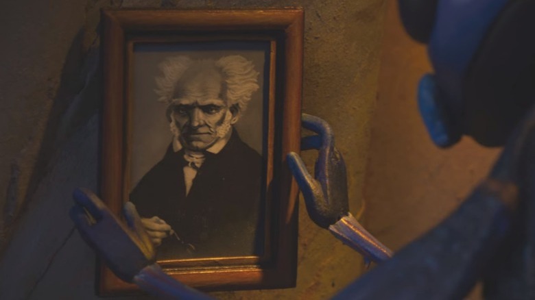 Sebastian hangs a portrait of Arthur Schopenhauer