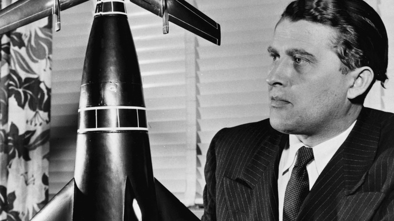 Wernher von Braun looking at rocket model