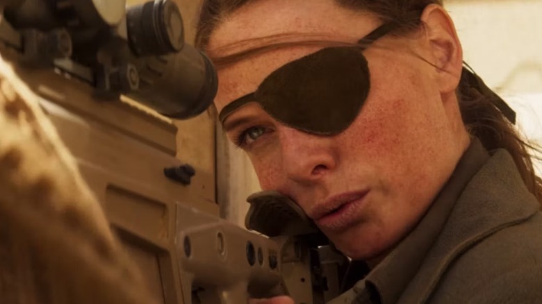 Ilsa wearing eyepatch while aiming rifle