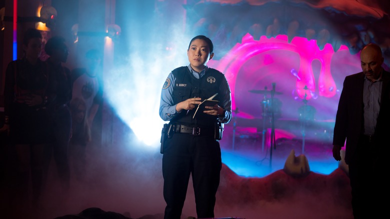 Awkwafina standing in a police uniform