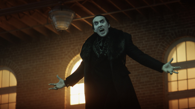 Nicolas Cage as Dracula hovering and holding out his arms