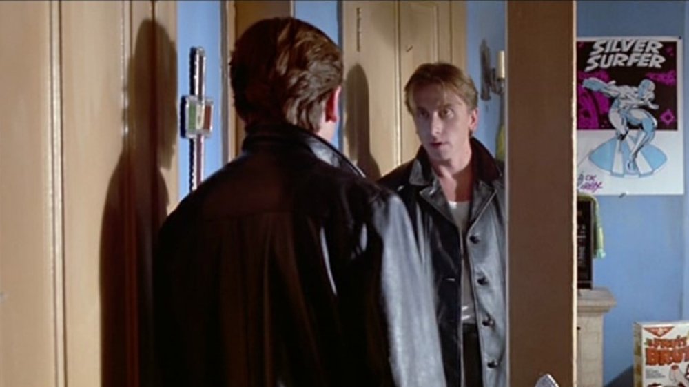 A young man in a leather jacket addresses himself in the mirror