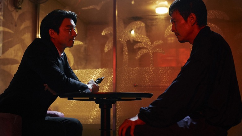 The Salesman with a gun talking to Gi-hun