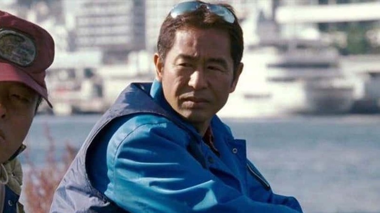 Fisherman sits on boat with sunglasses on his head