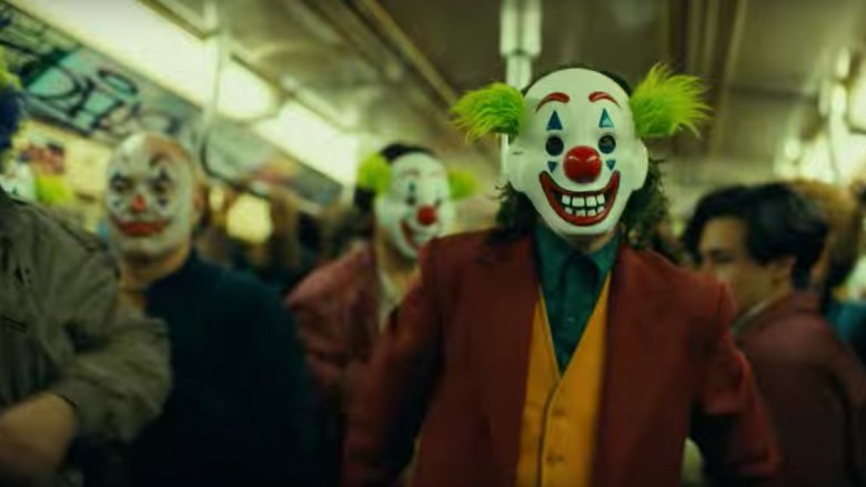 Joker wearing a clown mask on a subway