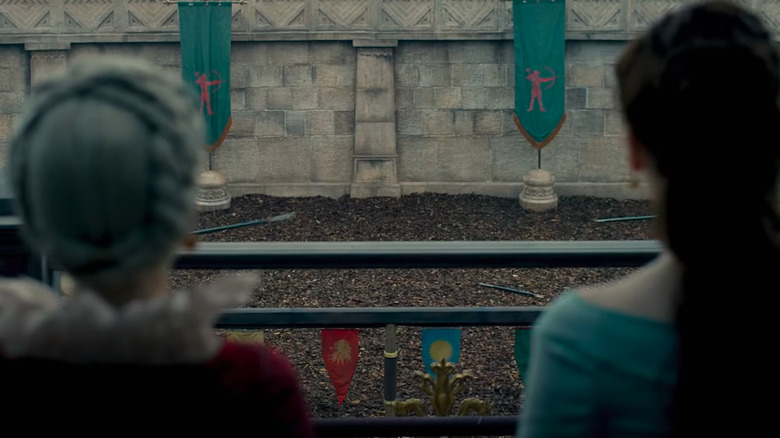 Two women watch a joust featuring Tarly banners