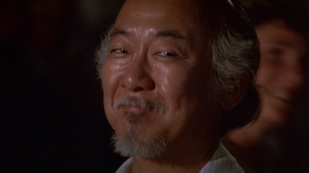 Mr. Miyagi looks on with a smug expression.