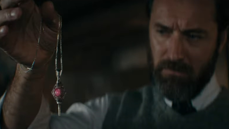 Dumbledore holds the ruined blood pact pendant