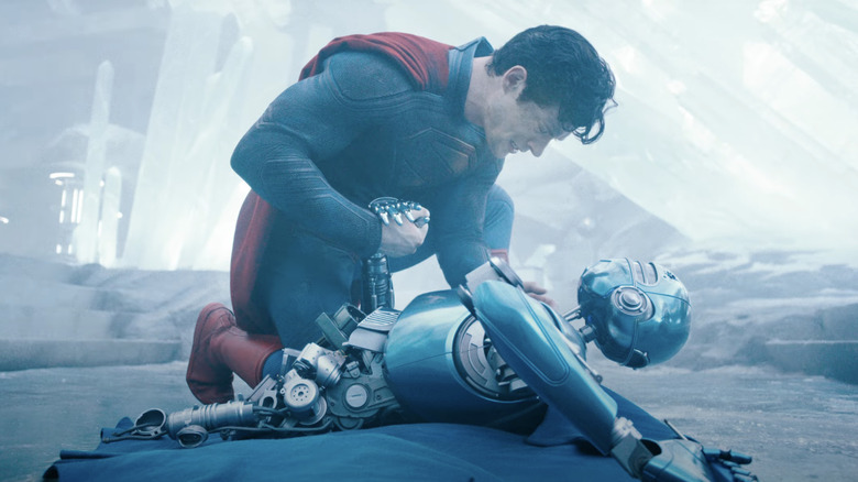 Superman holds the hand of his dying robot companion in "Superman" (2025)