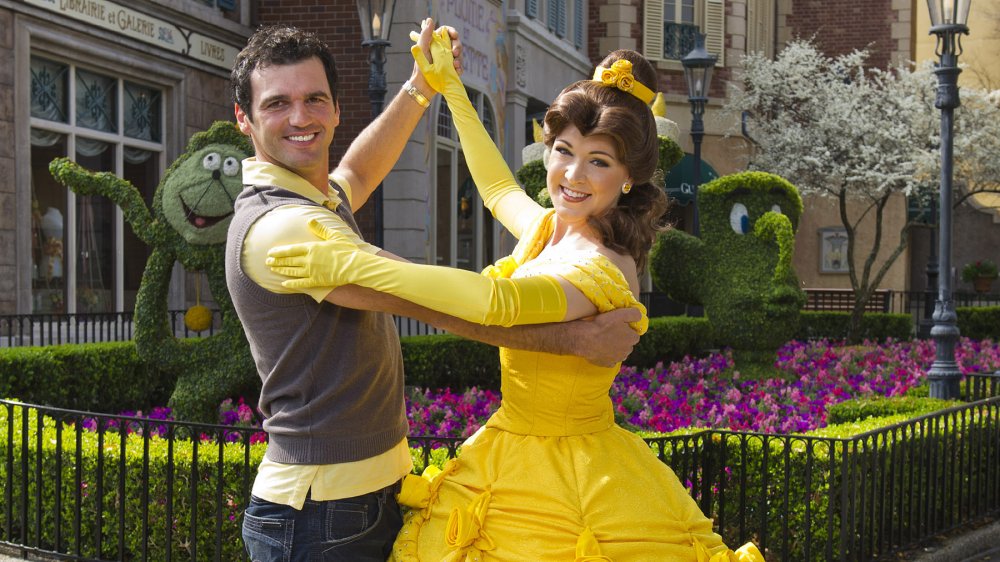 Princess Belle from Beauty and the Beast dances with a guest in Disney World