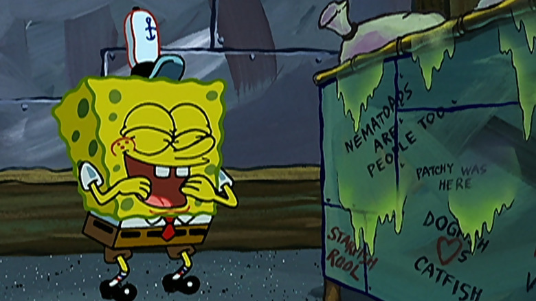 SpongeBob laughing near a dumpster