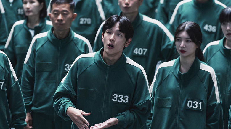 Im Si-wan as Lee Myung-gi, Player 333, standing with other players and speaking on Squid Game Season 2