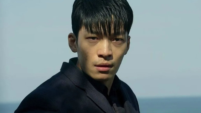 Wi Ha-joon as Hwang Jun-ho, standing on a cliff's edge on Squid Game