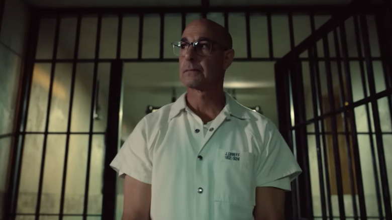 Stanley Tucci as Jefferson Grieff standing in front of prison bars