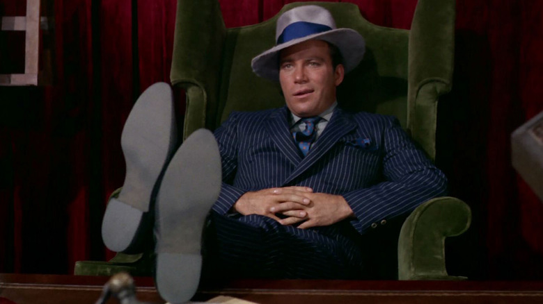 Captain Kirk in a pinstripe suit with his feet on a desk