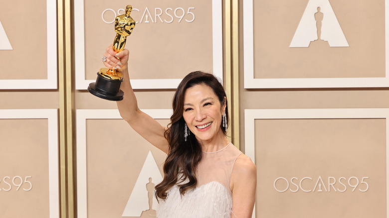 Michelle Yeoh triumphantly clutches her Oscar statuette at the 2023 Academy Awards