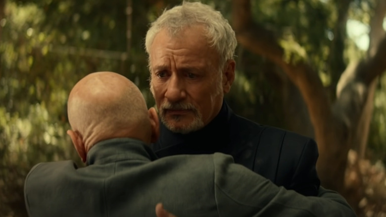 Q receiving a hug from Picard