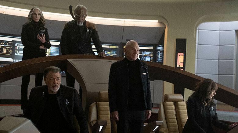 Jean-Luc Picard standing with crew members on bridge