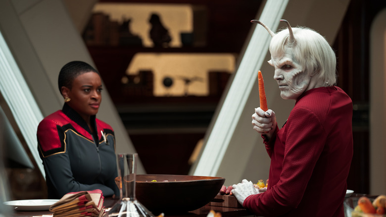 Uhura looks at Hemmer holding a carrot