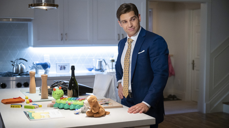 Cooper leaning on toy-covered kitchen counter