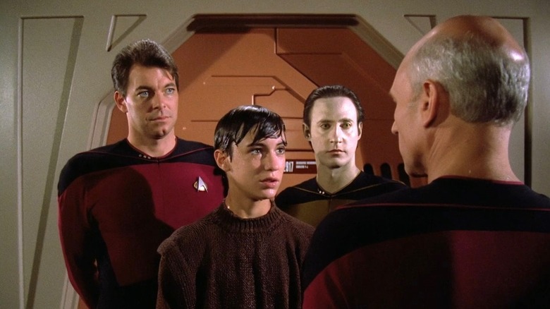 Riker, Wesley, and Data stand in front of Picard