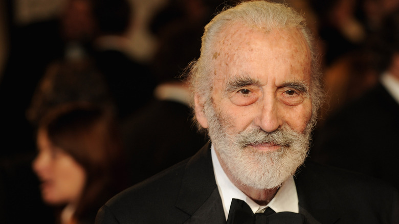 Christopher Lee smiles for the camera in a suit